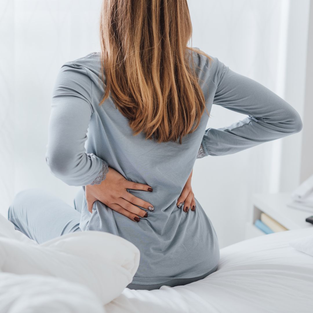 woman holding her back in pain