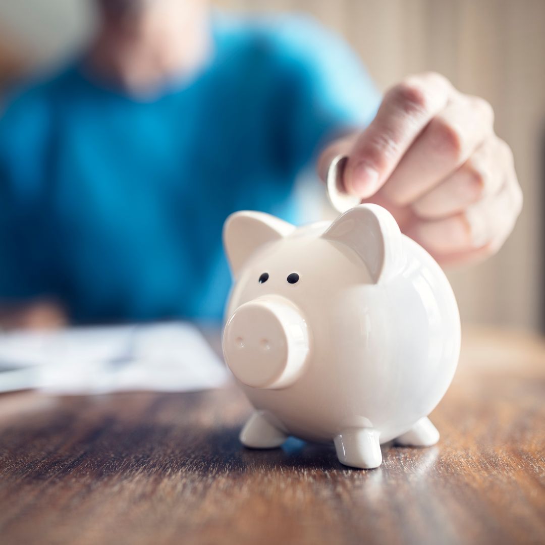 someone putting money in a piggy bank