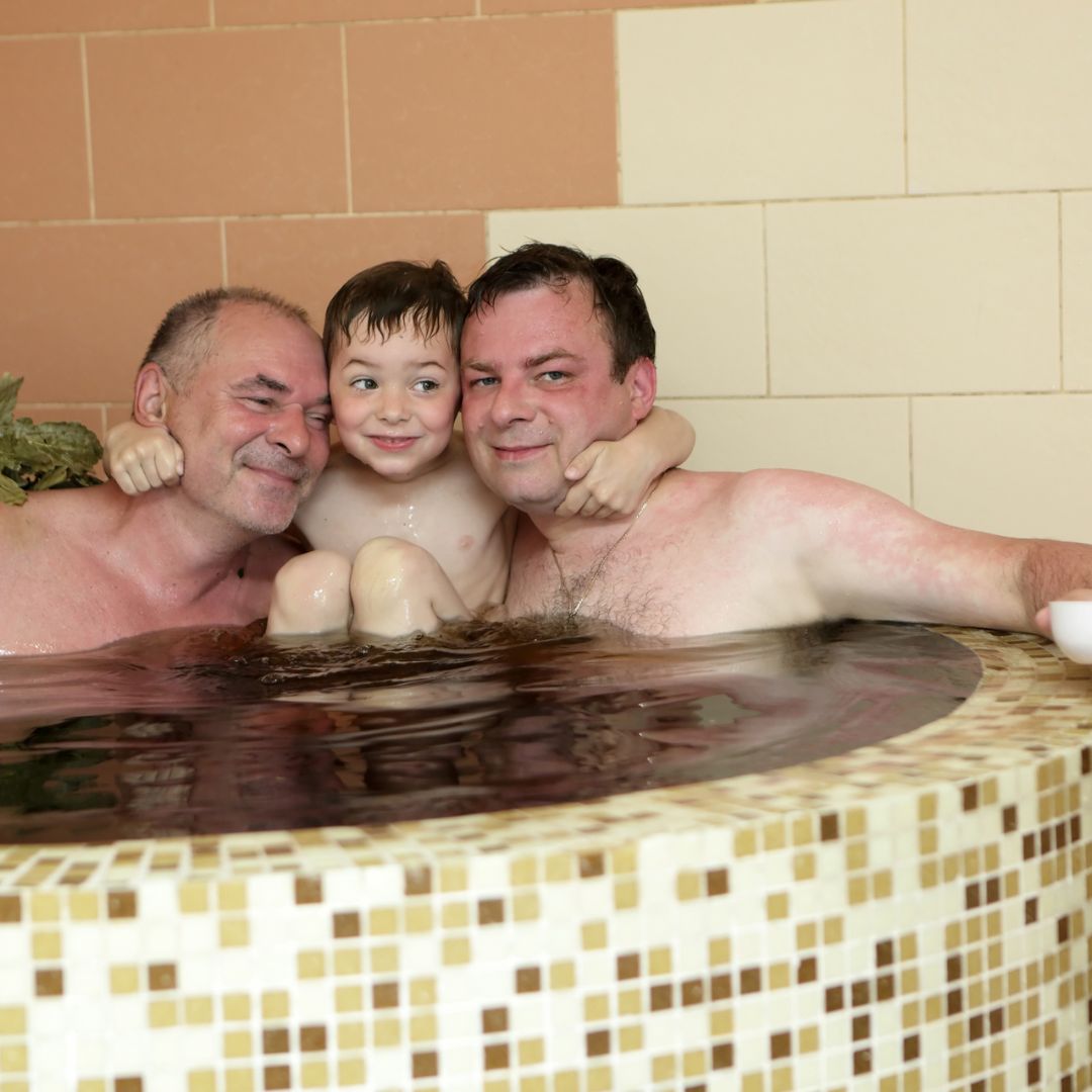 Gay couple and child in hot tub