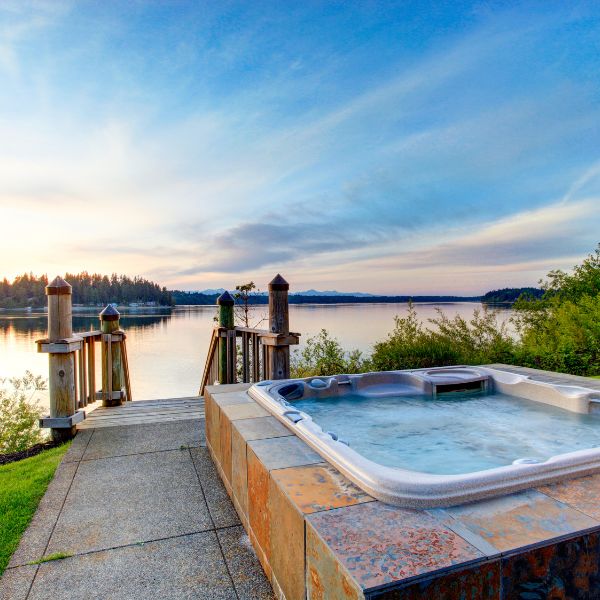 A hot tub sitting right in front of a lake 