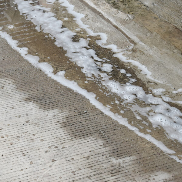 Concrete with a pool of water sitting on it.